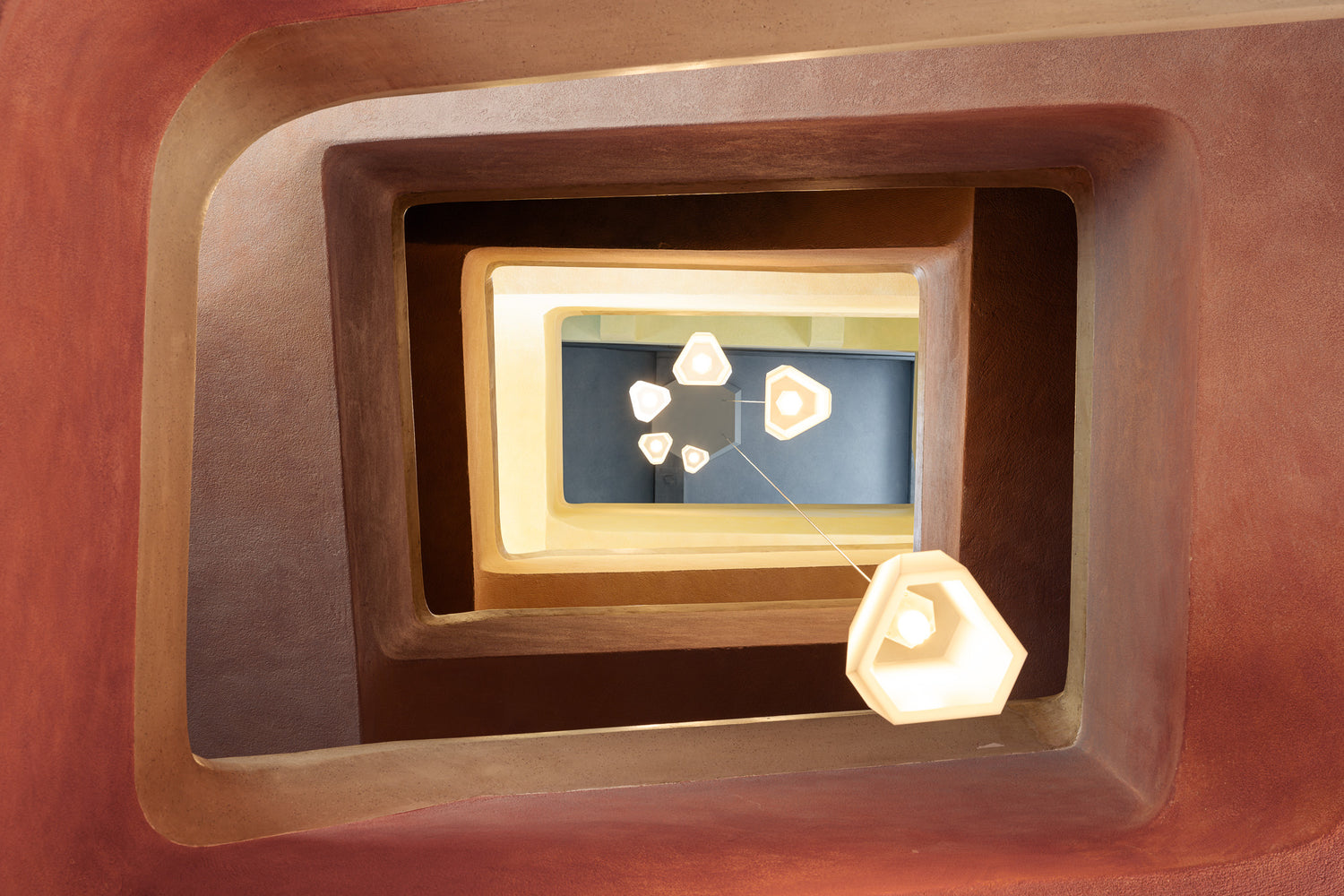 goetheanum rudolf steiner looking up stairwell warm earth tones pendant lights thibaud poirier