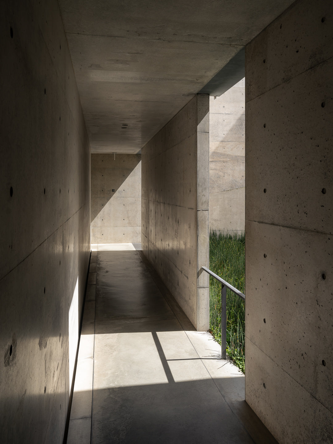 naoshima-tadao-ando-concrete-corridor-natural-light-vegetation-thibaud-poirierchichu-art-museum