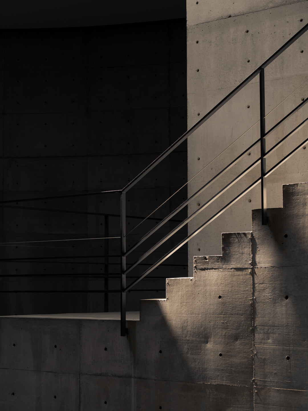 naoshima-tadao-ando-concrete-stairs-metal-railing-dramatic-light-thibaud-poirier-Benesse-House