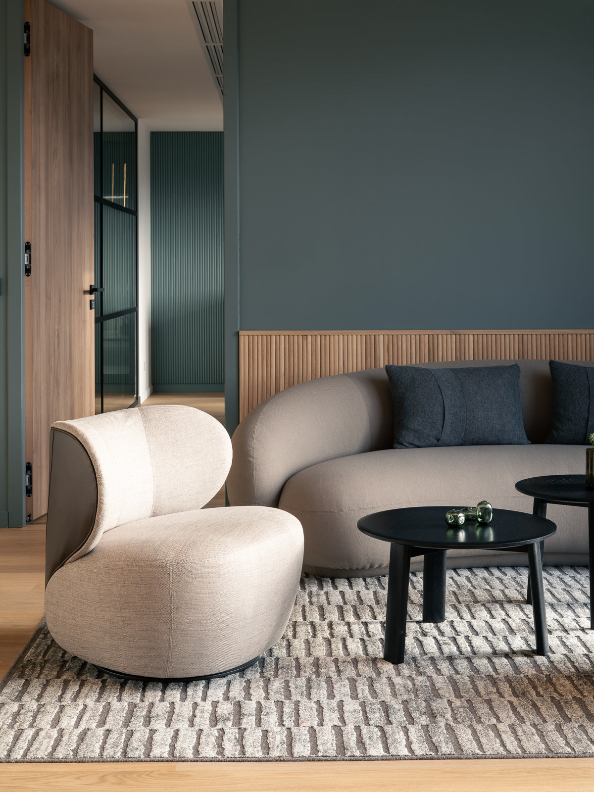 workplace-design-lounge-canape-courbe-beige-table-basse-noire-boiseries-thibaud-poirier