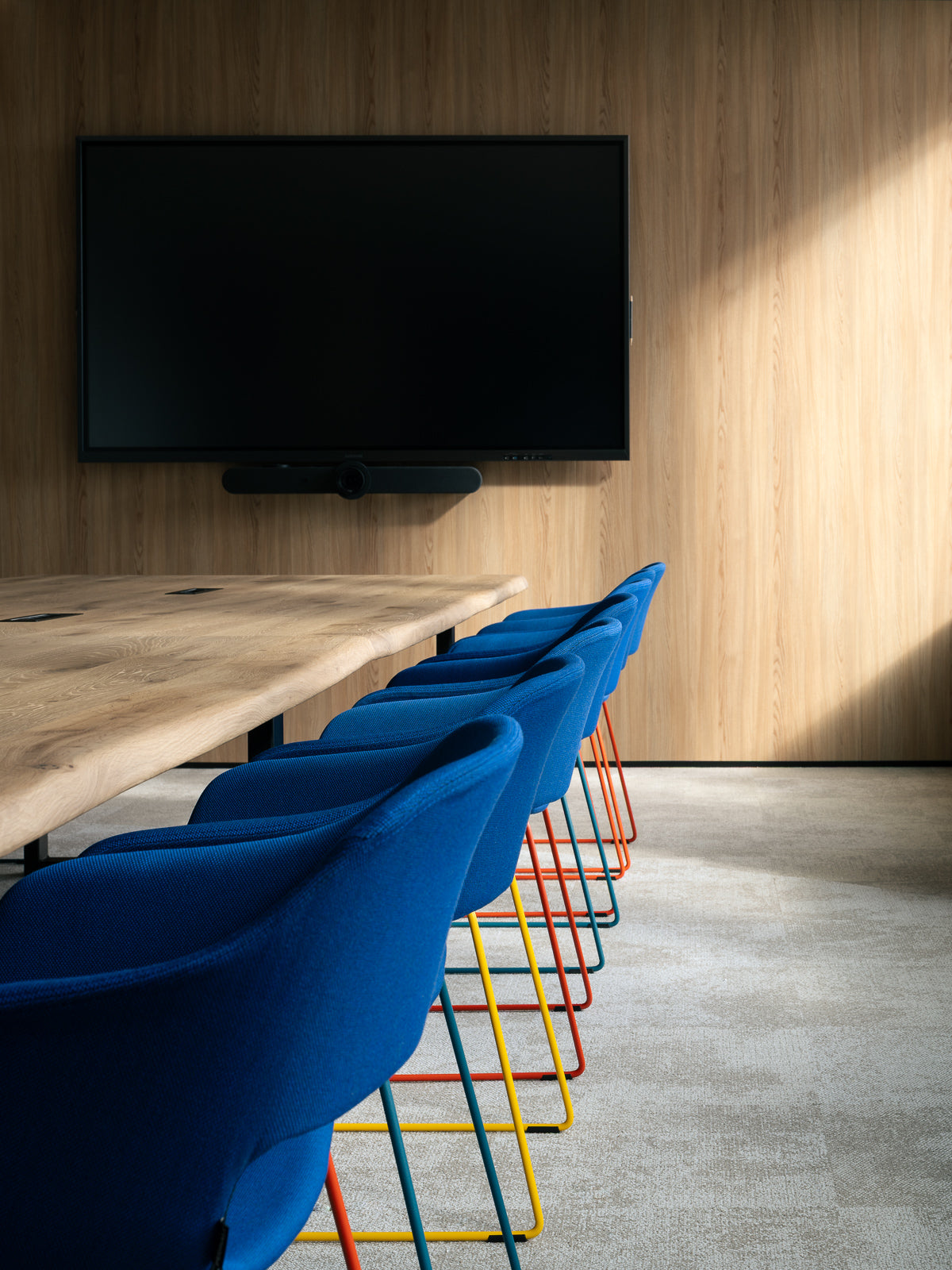 workplace-design-salle-reunion-chaises-bleues-pieds-colores-table-bois-brut-thibaud-poirier